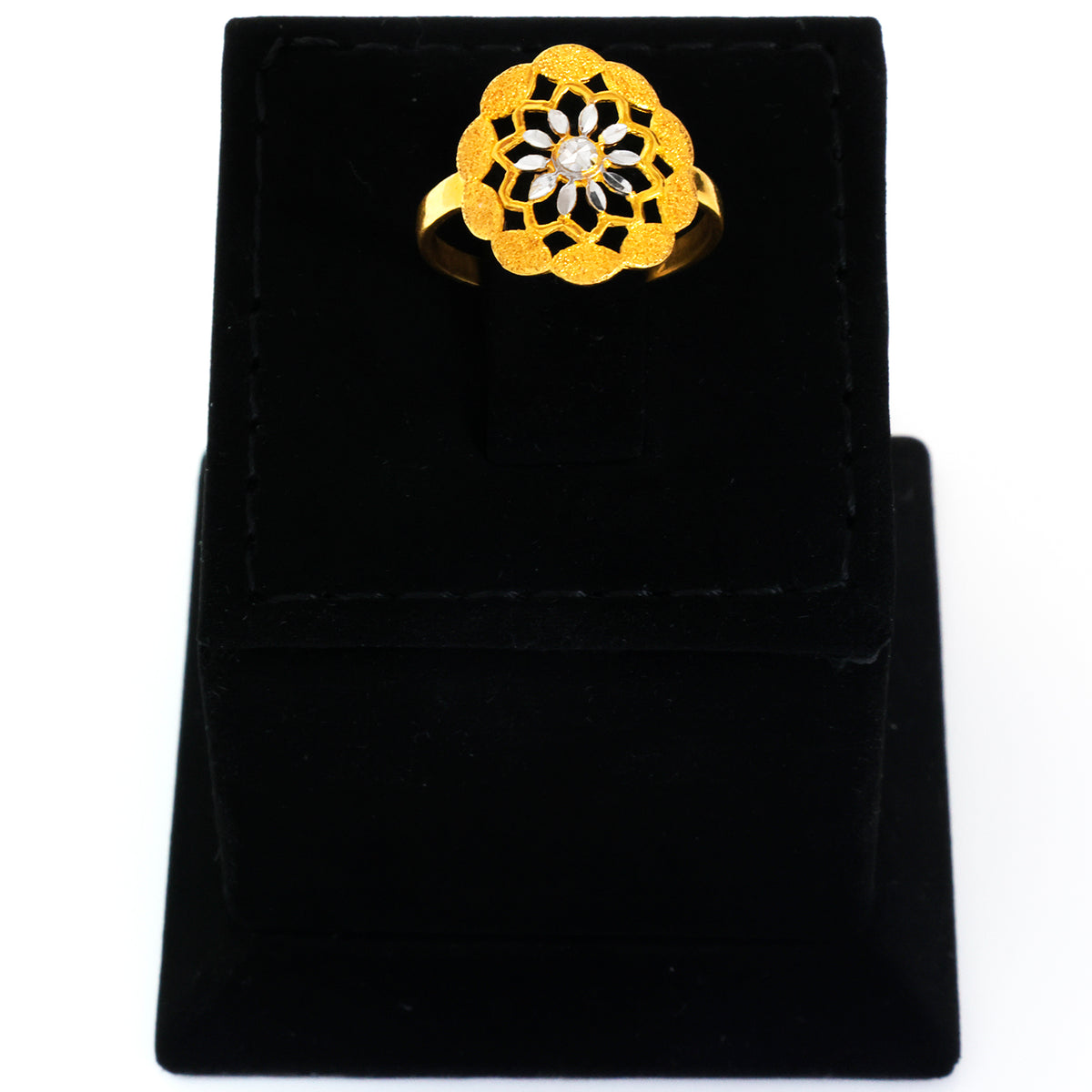 Gold ring with a central gemstone on a black velvet stand