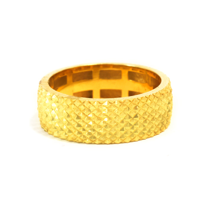 Gold ring with textured pattern on a white background