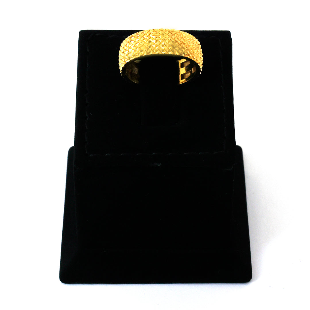 Gold ring on a black velvet stand against a white background