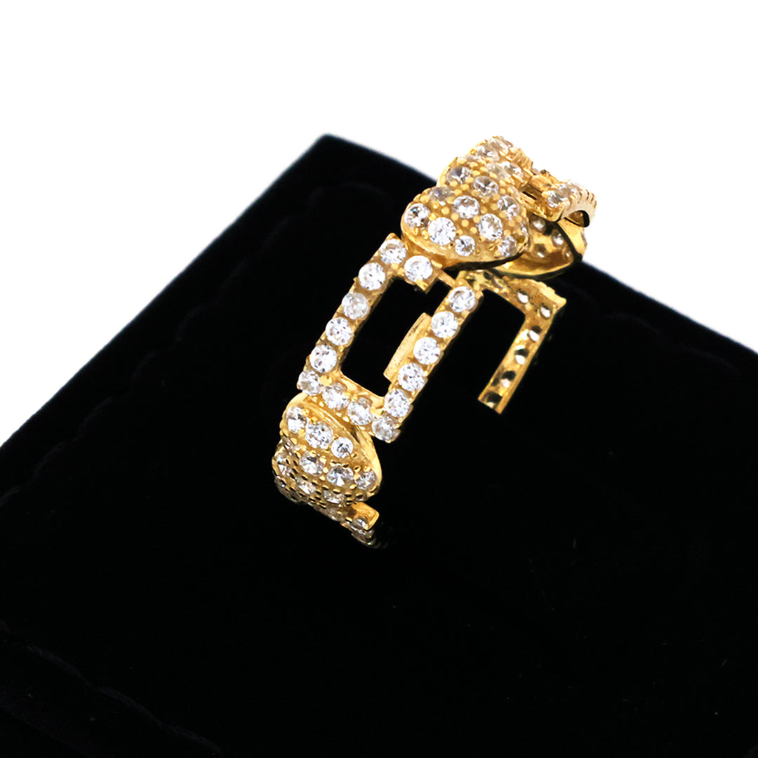 Gold pendant with clear stones on a black background