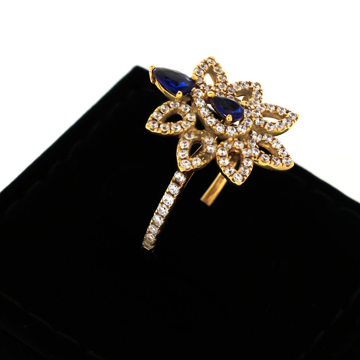 Gold brooch with blue gemstones on a black background