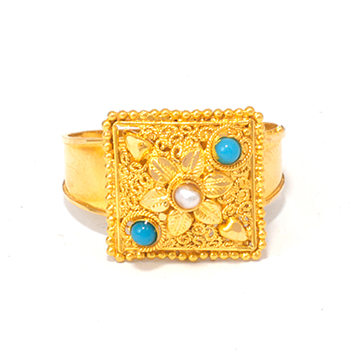 Gold ring with floral design and blue gemstones on a white background