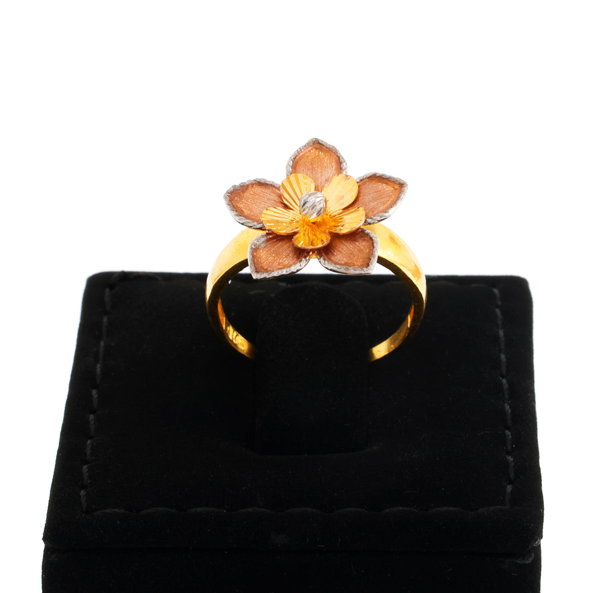 Gold and brown flower-shaped ring on a black velvet stand with a white background