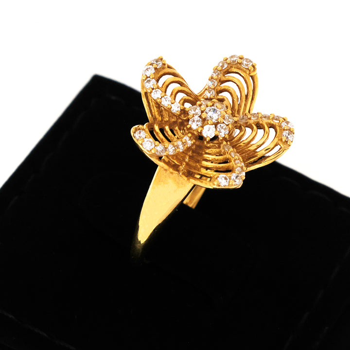 Gold butterfly ring with gemstones on a black background
