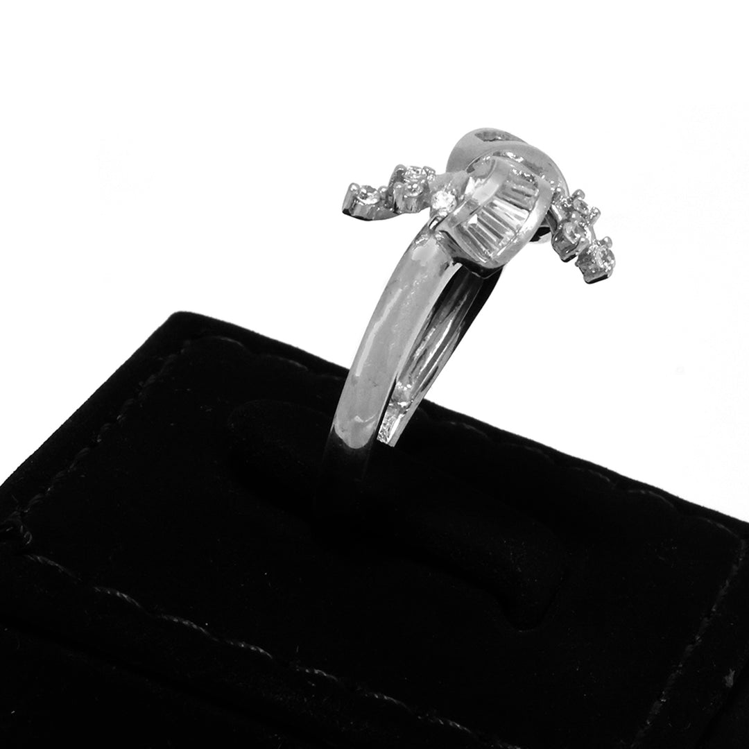 Silver ring with a large central diamond and smaller diamonds on a black velvet cushion