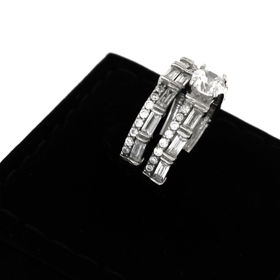 Pair of silver hoop earrings with clear gemstones on a black velvet background