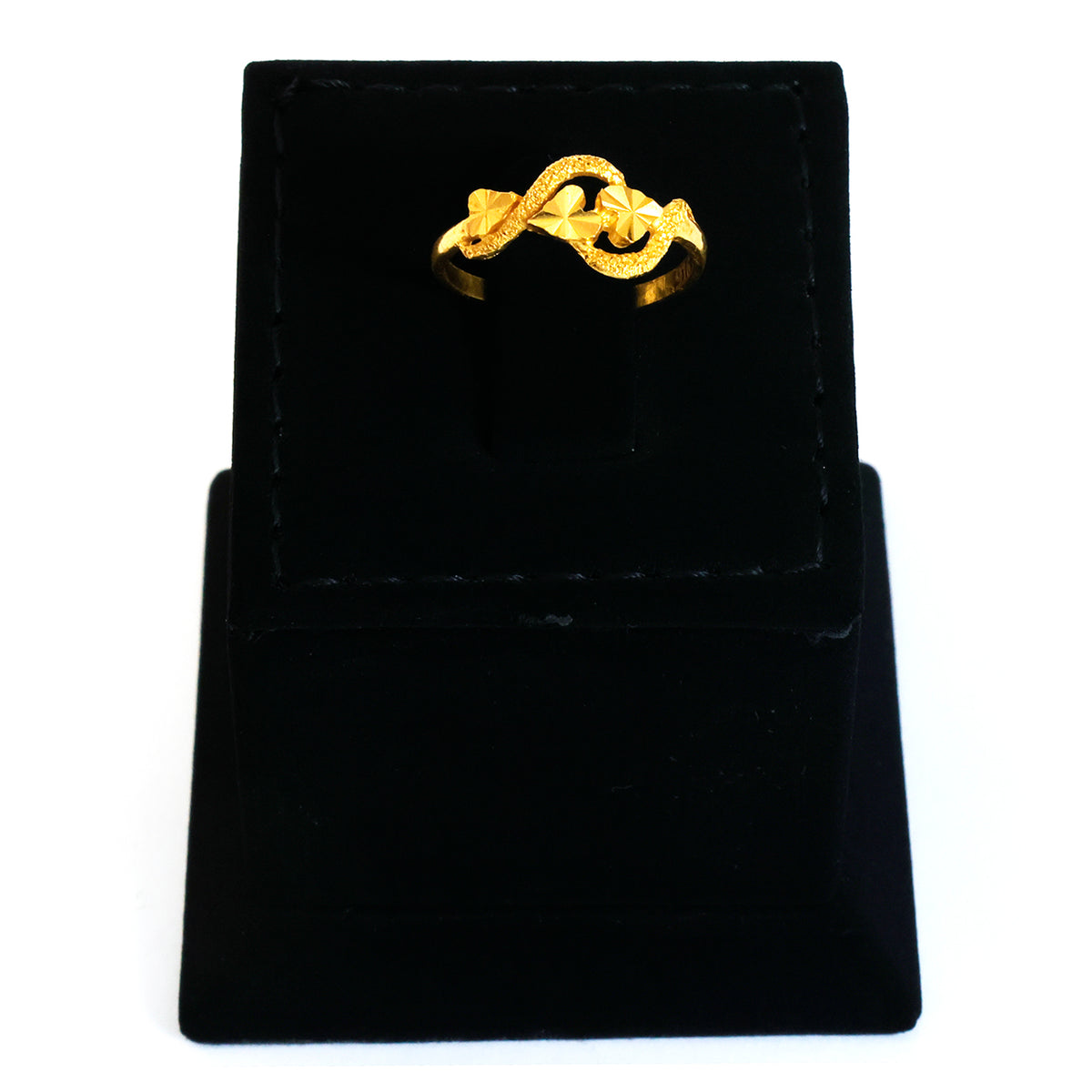 Gold ring on a black velvet stand with a white background