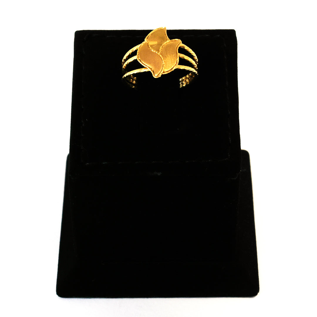 Gold bracelet on a black velvet stand with a white background