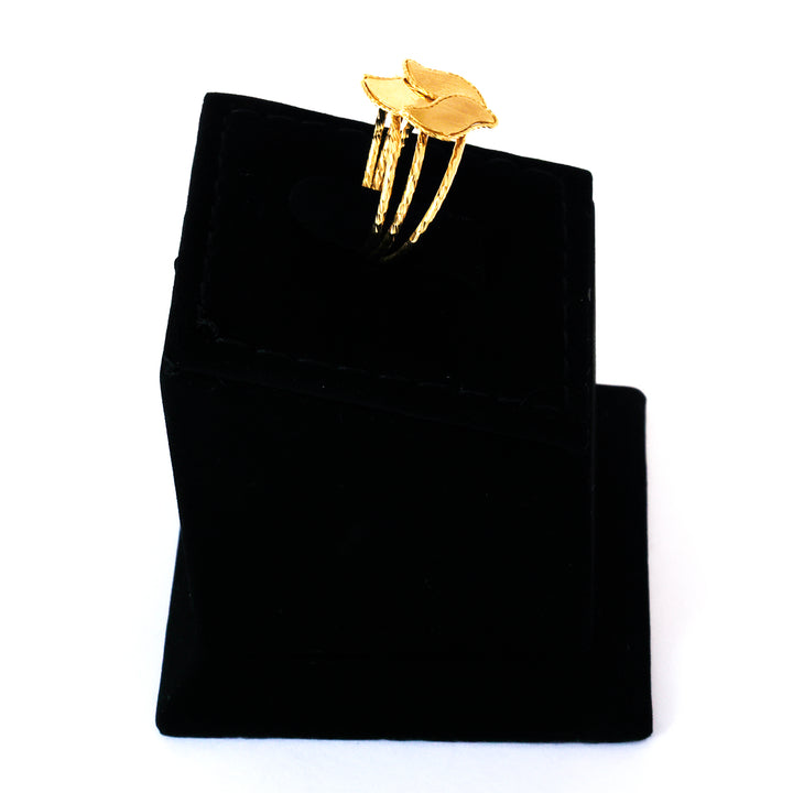 Gold ring on a black velvet jewelry pouch against a white background
