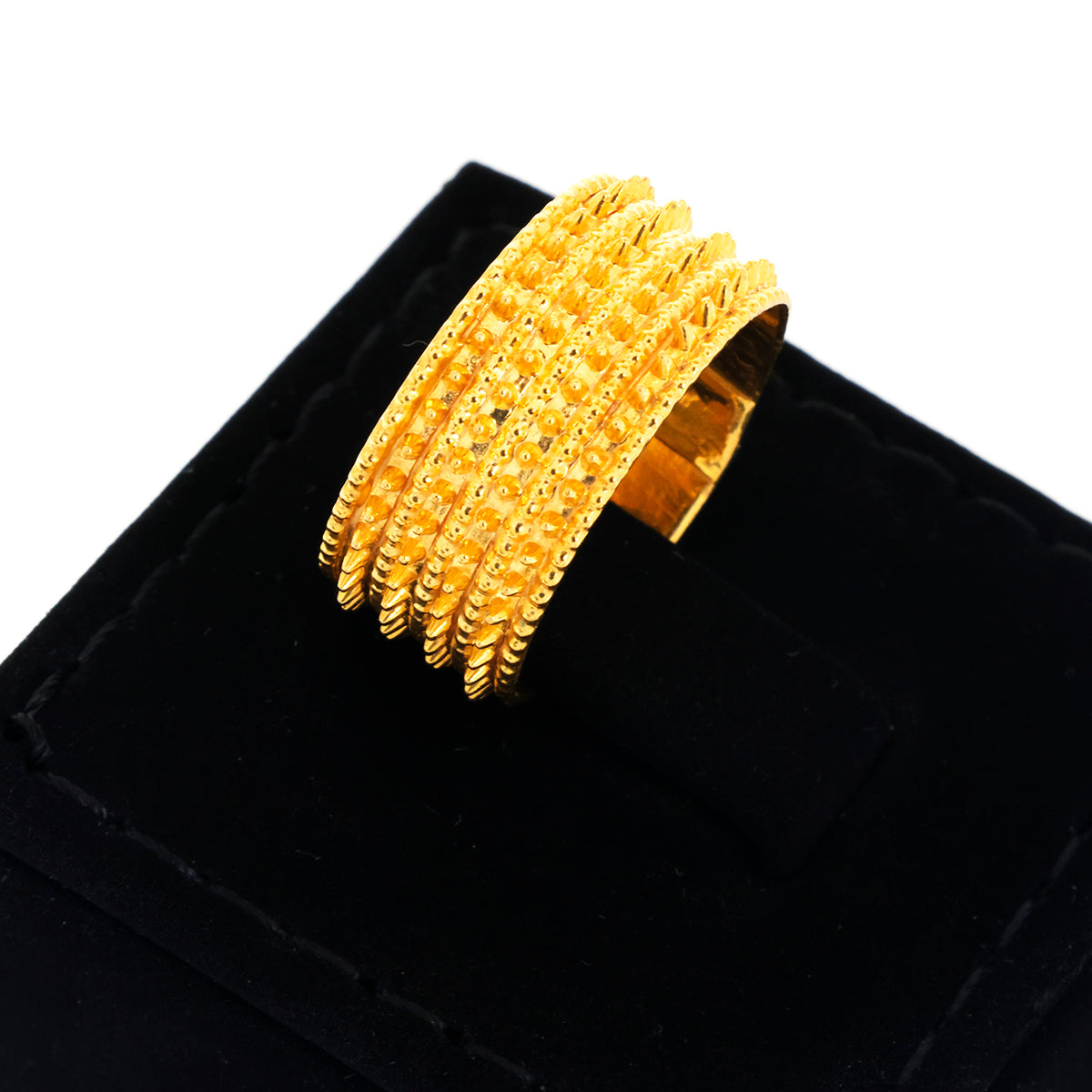 Gold bracelet on a black velvet surface