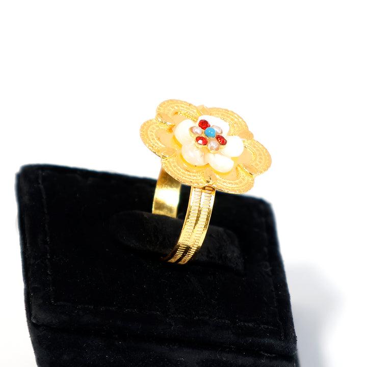 Gold ring with a floral design on a black velvet cushion