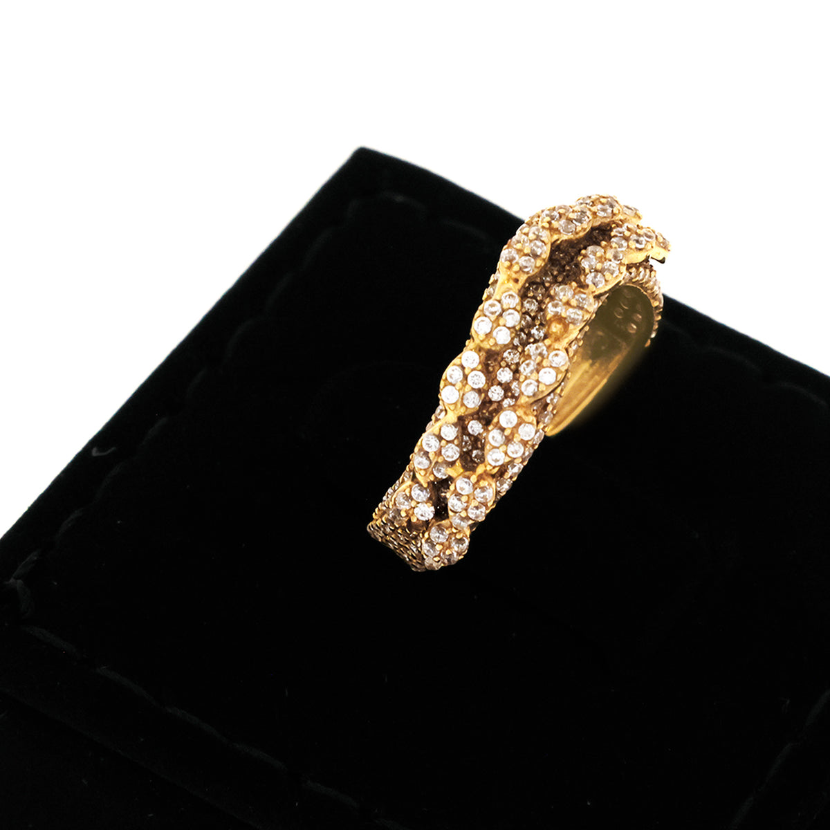 Gold bracelet with embedded stones on a black velvet surface