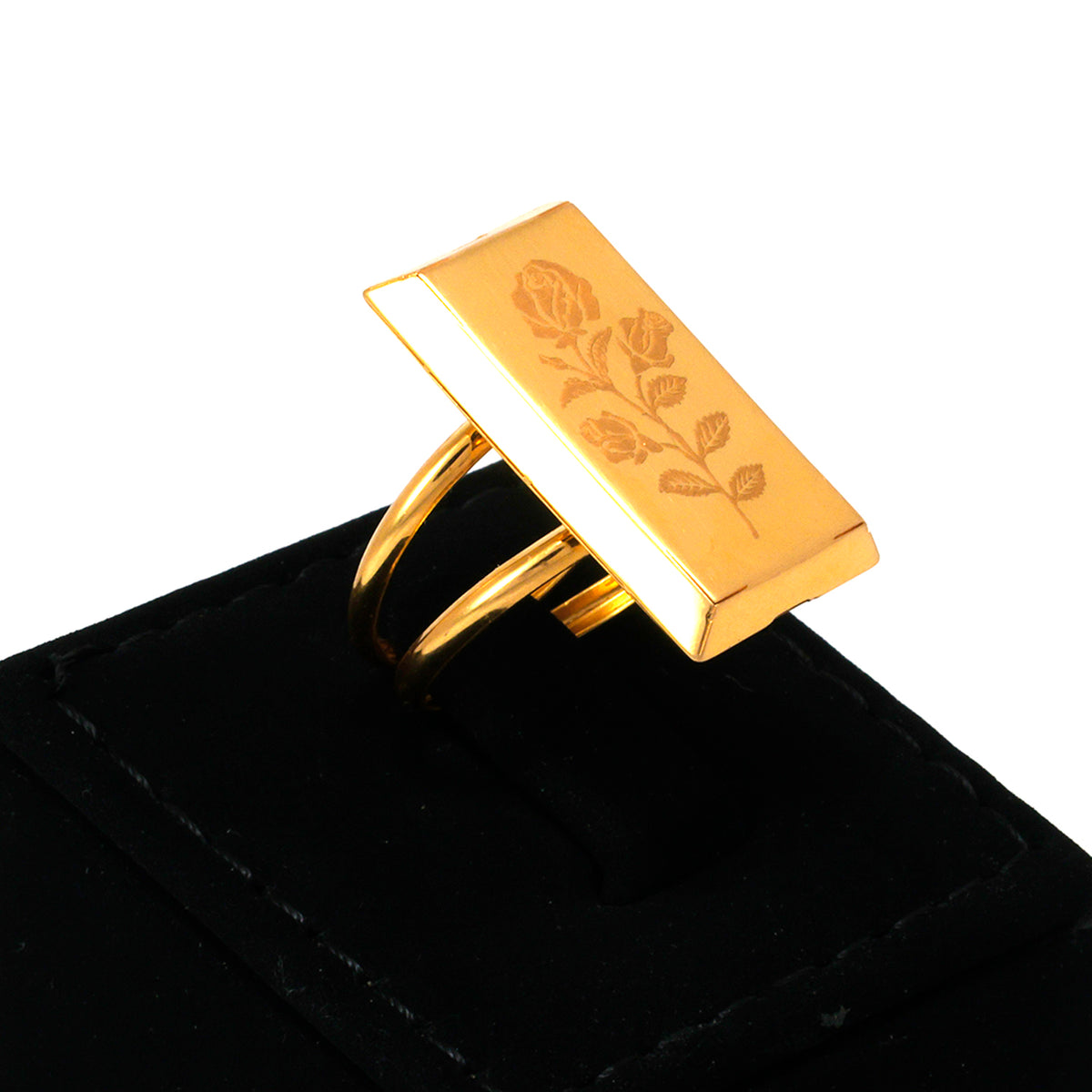 Gold ring with floral engraving on a black surface
