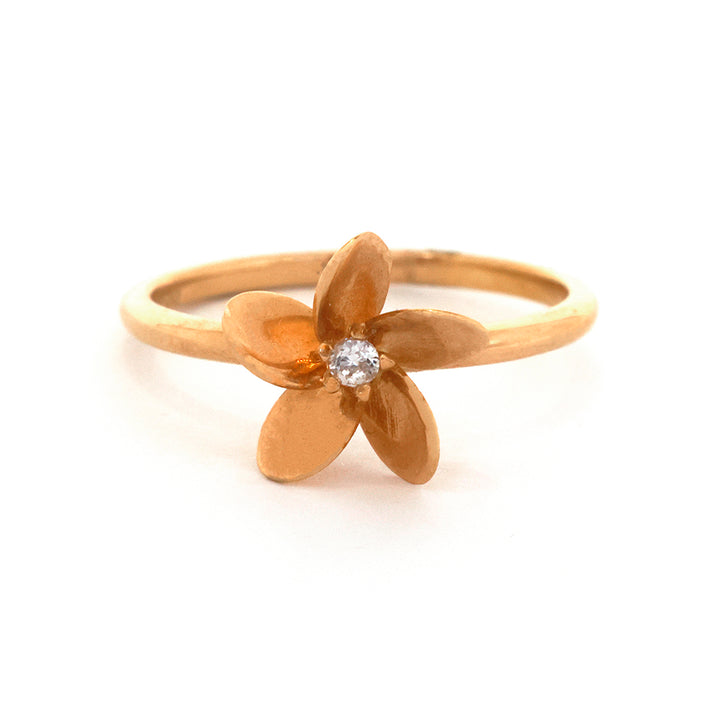 Gold flower-shaped ring with a diamond on a white background