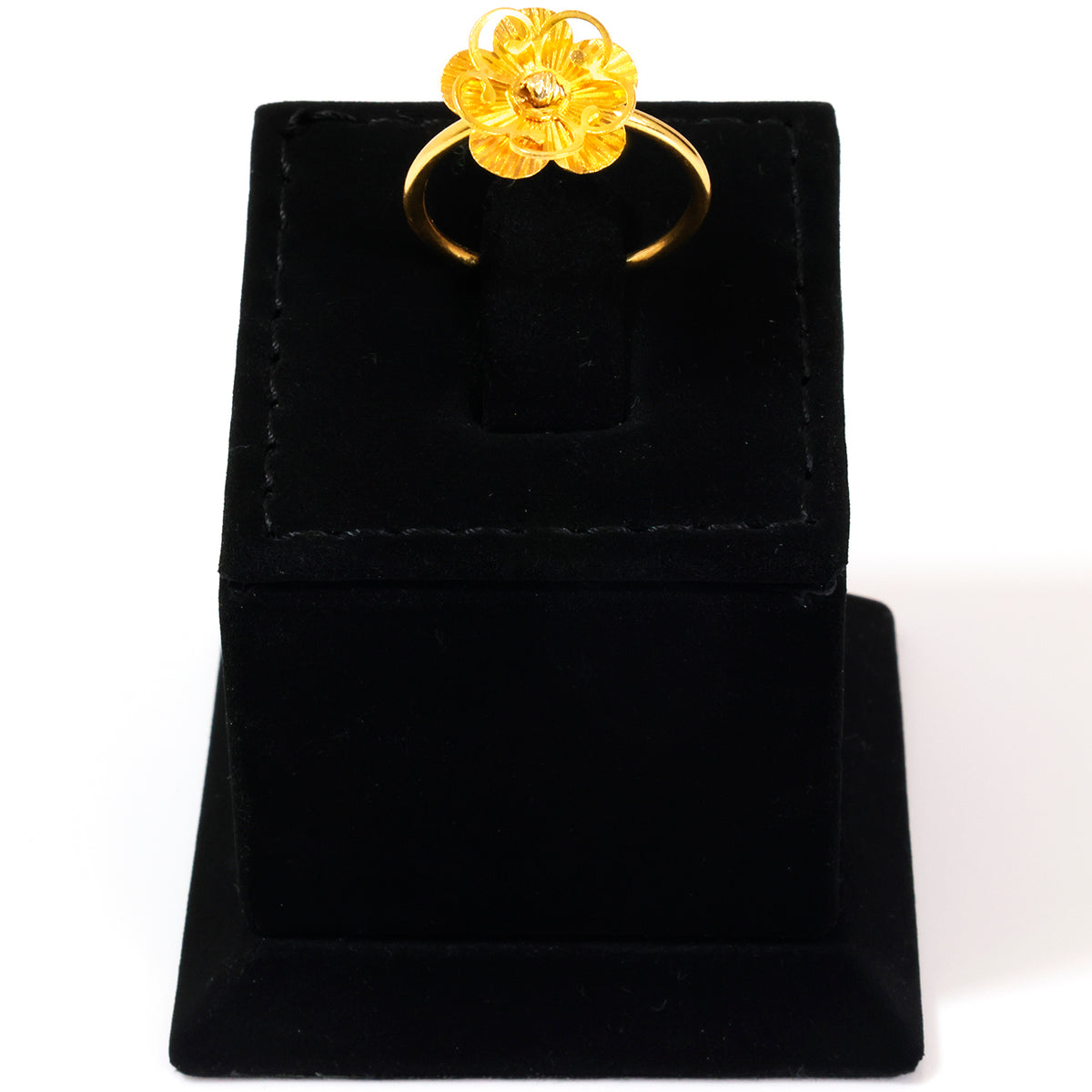 Gold ring on a black velvet stand against a white background