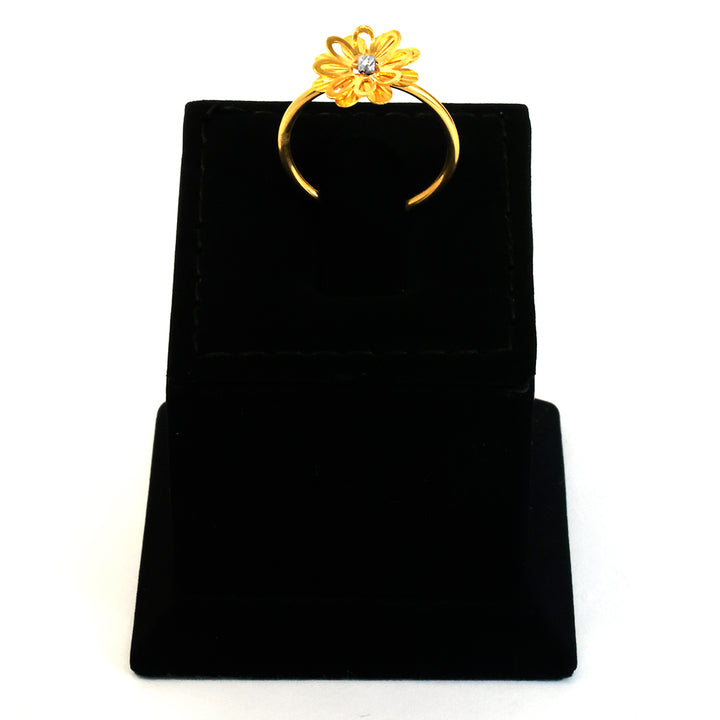 Gold ring with a floral design on a black velvet stand