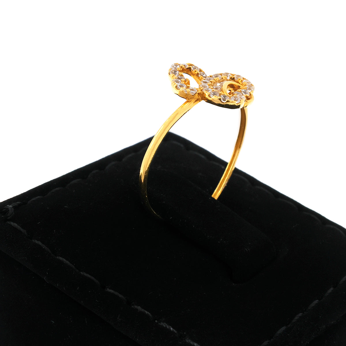 Gold bow-shaped ring on a black velvet cushion