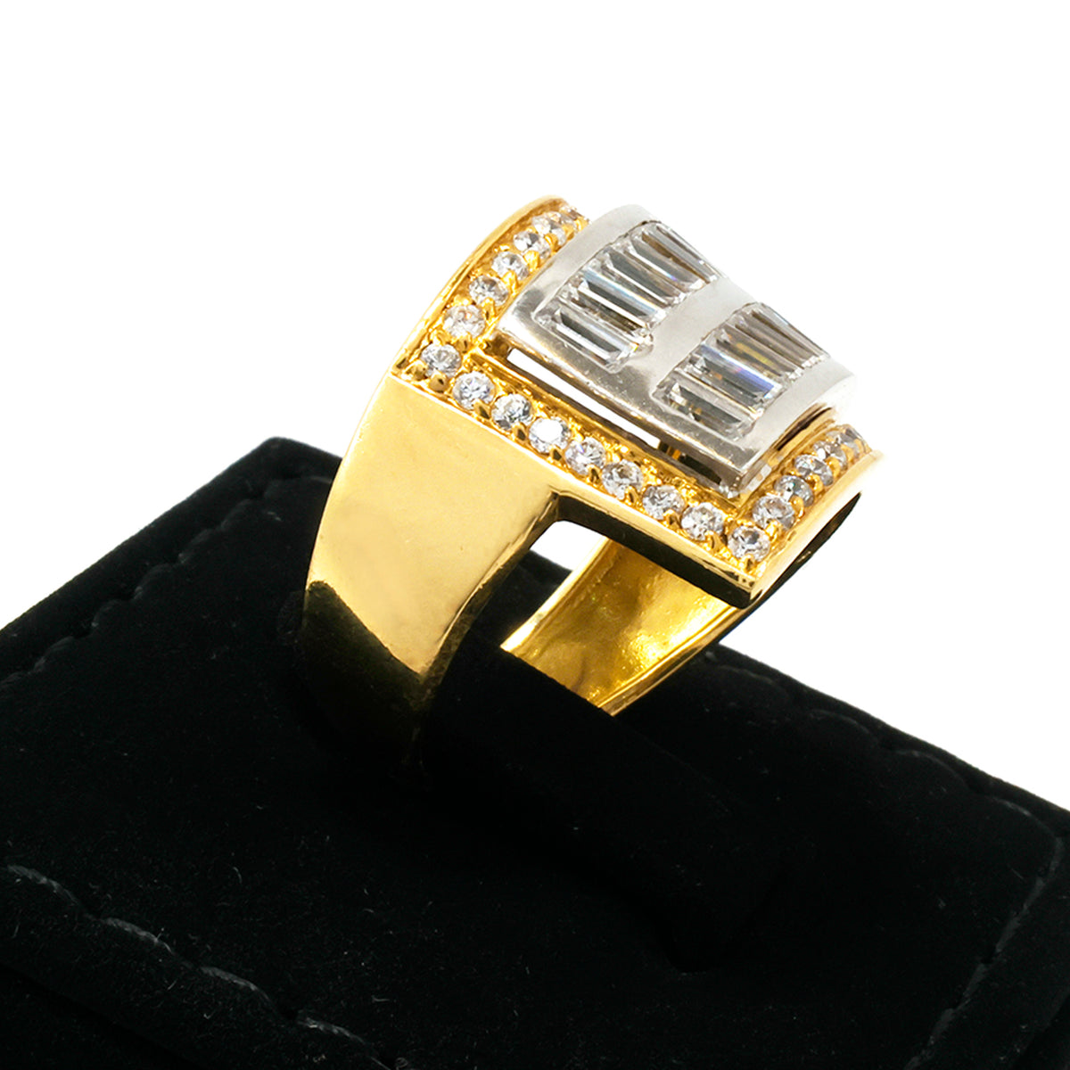 Gold and silver ring with gemstones on a black stand