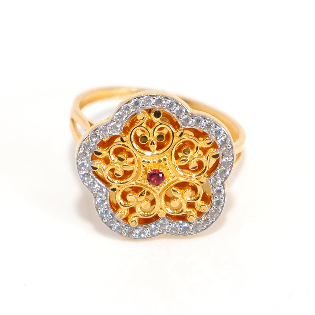 Gold ring with intricate design and a red gemstone on a white background