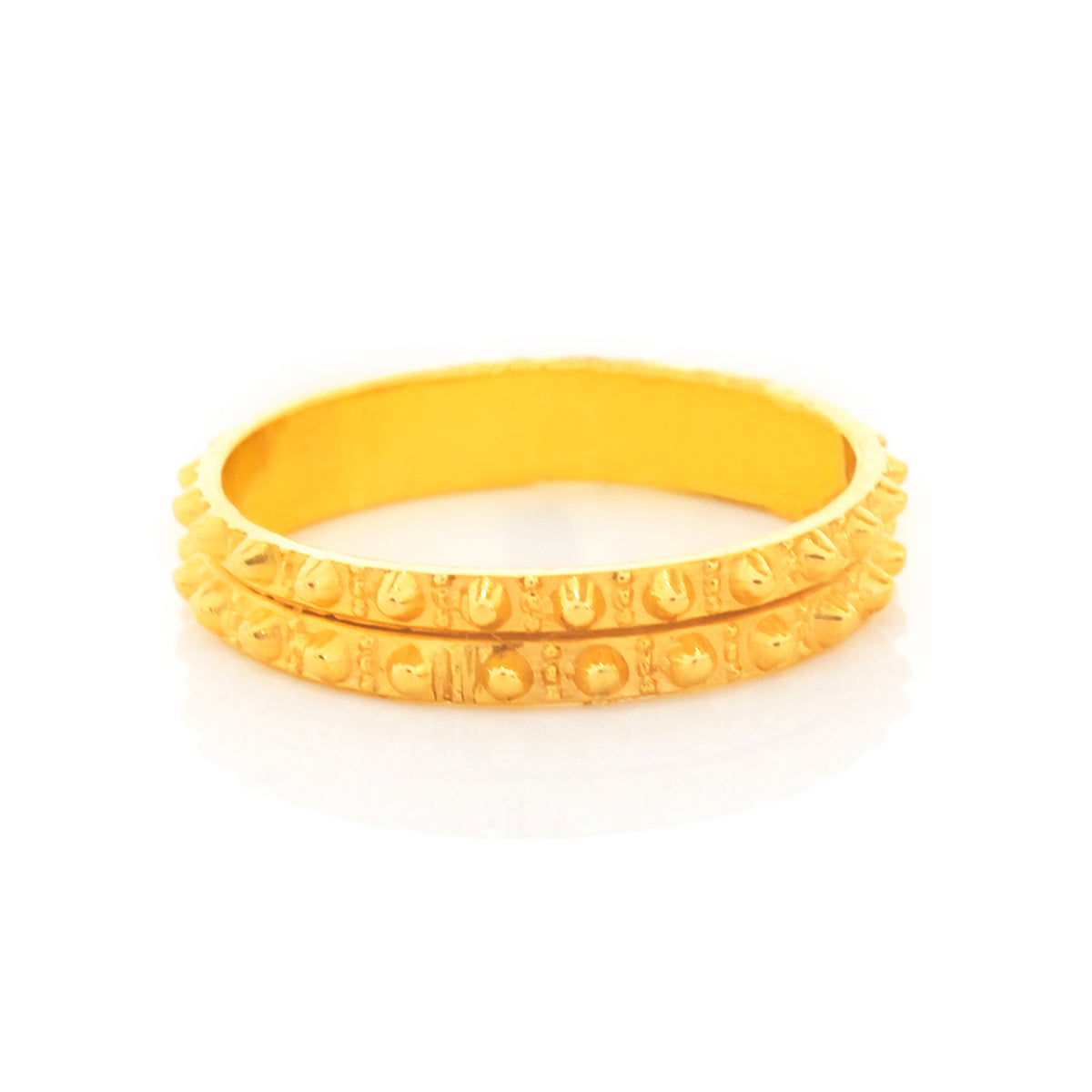 Two gold bangles stacked on a white background