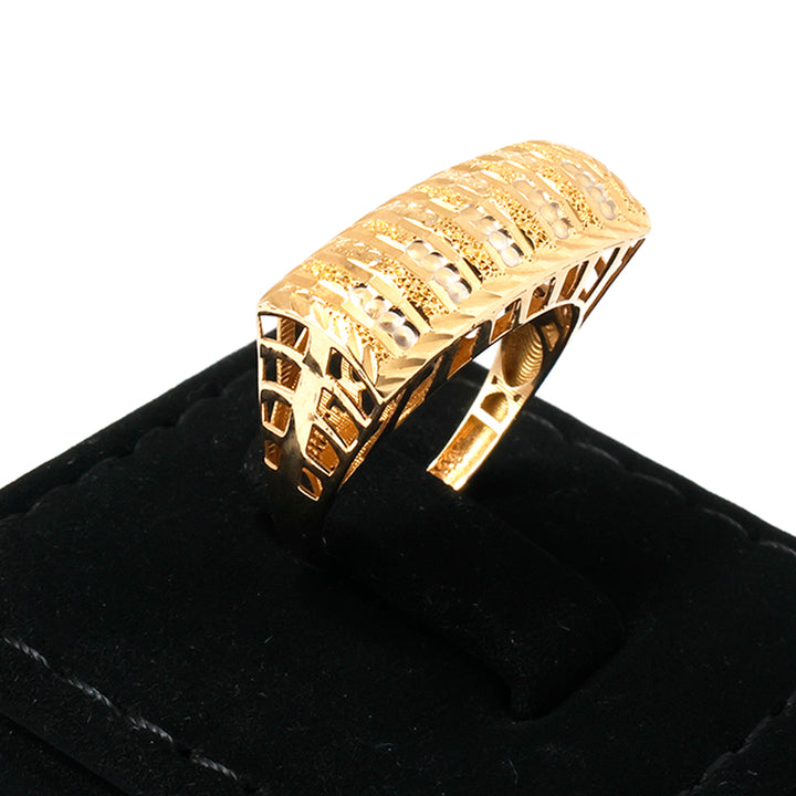 Gold ring with intricate design on a black cushion against a white background