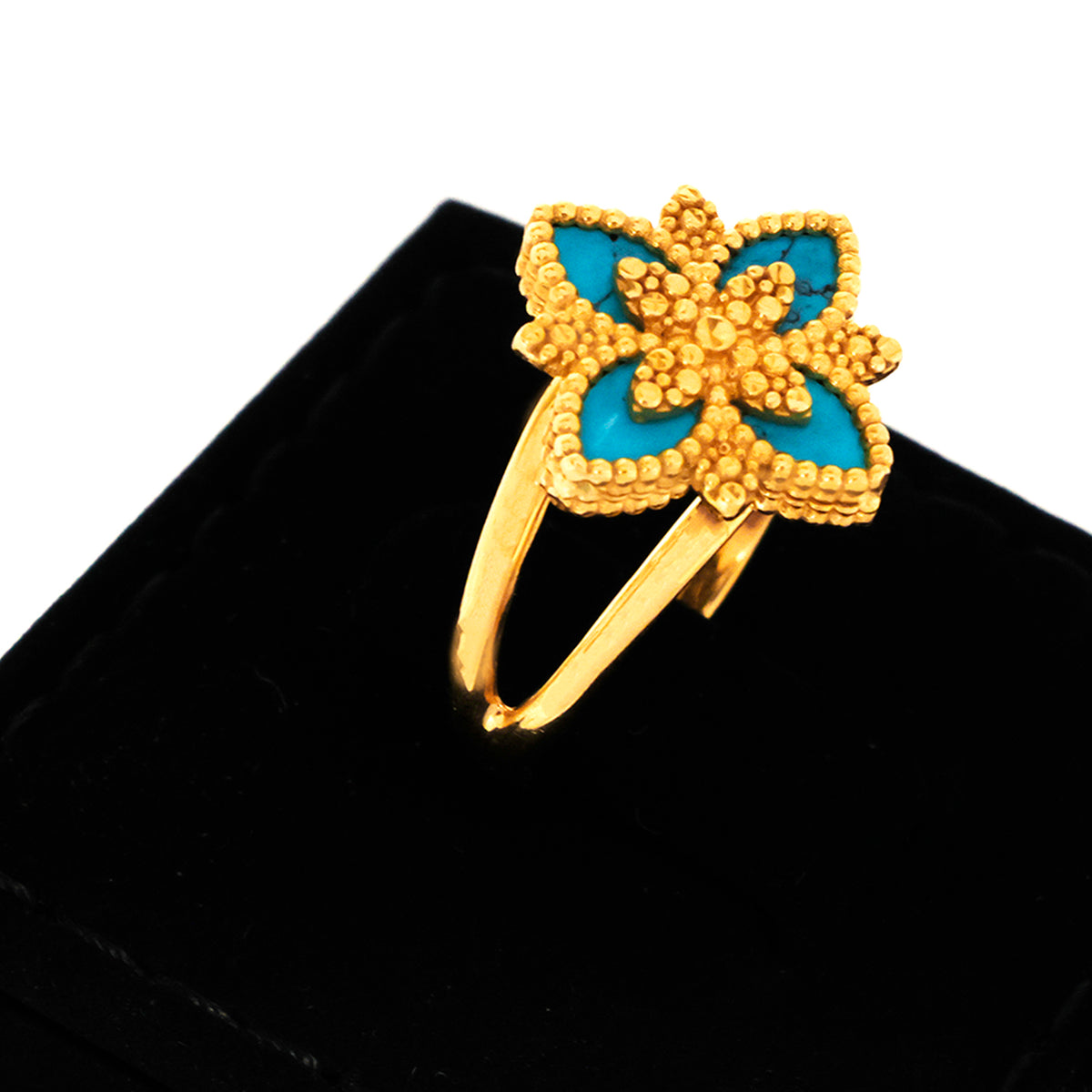Gold butterfly ring with blue center on a black background