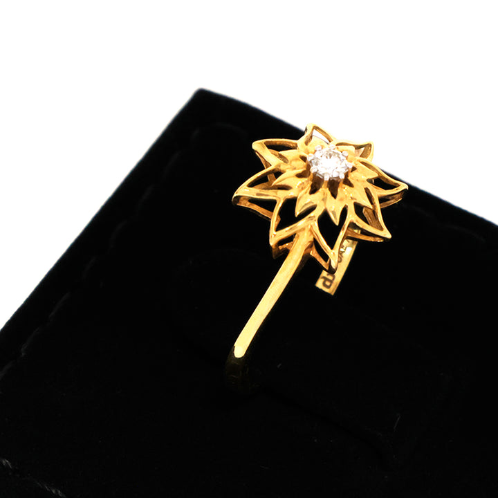 Gold ring with a diamond on a black background