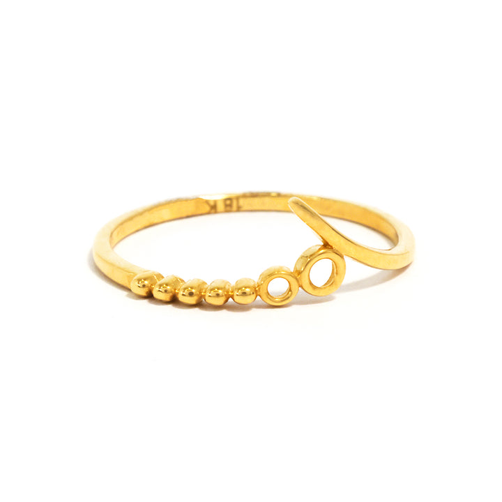 Gold ring with circular and bead designs on a white background