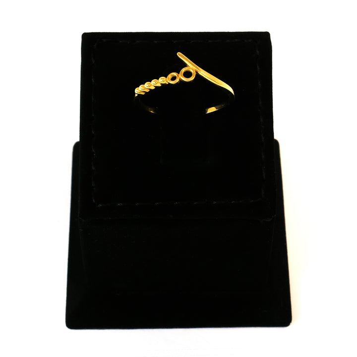 Gold ring with a unique design on a black velvet stand.