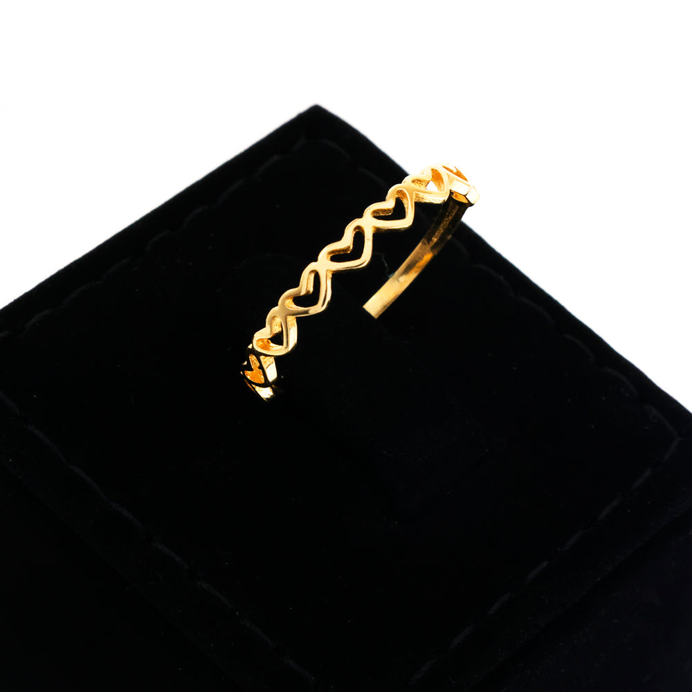 Gold ring with a wavy design on a black velvet surface