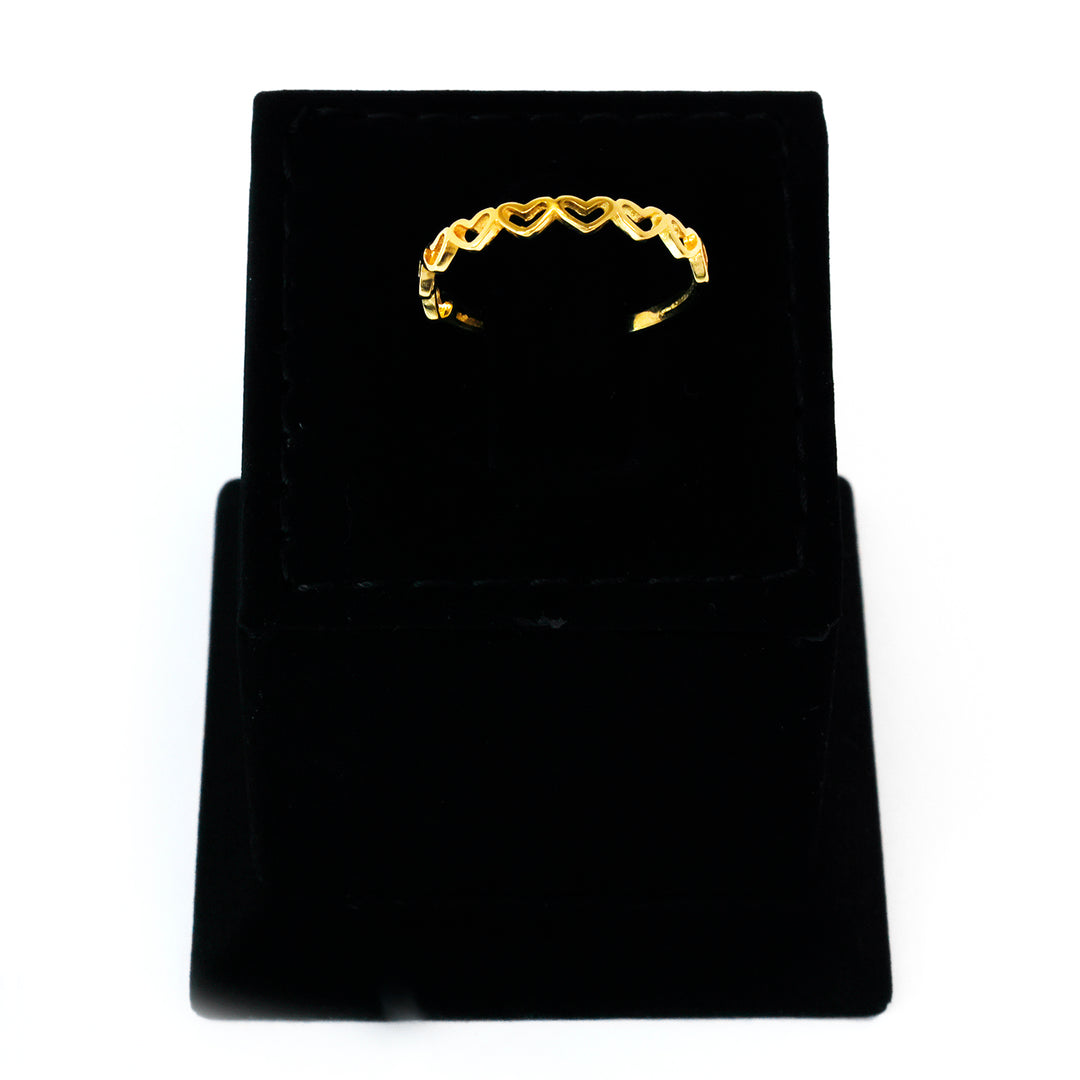 Gold ring on a black velvet stand against a white background