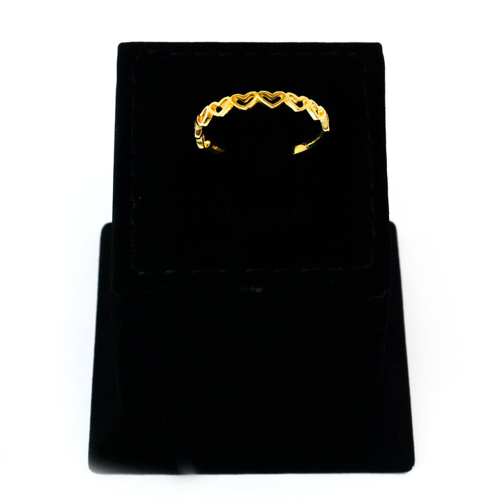 Gold ring on a black velvet stand against a white background