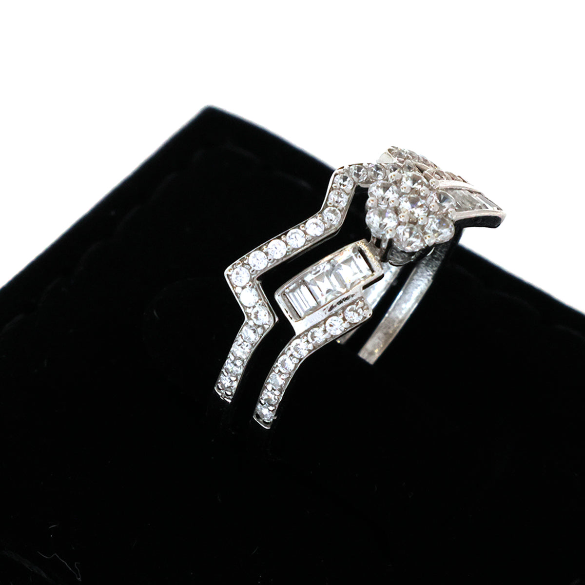 Silver ring with gemstones on a black cushion