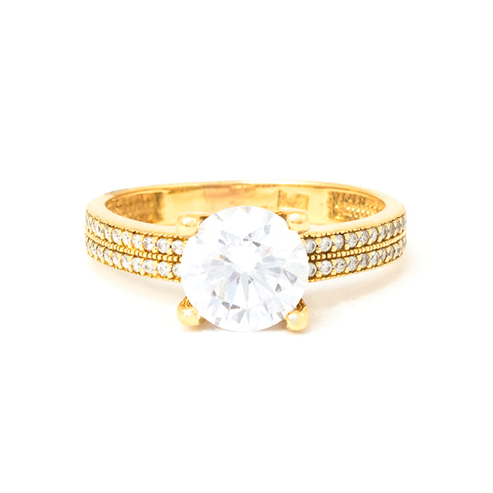 Gold ring with a large diamond and smaller diamonds on the band against a white background
