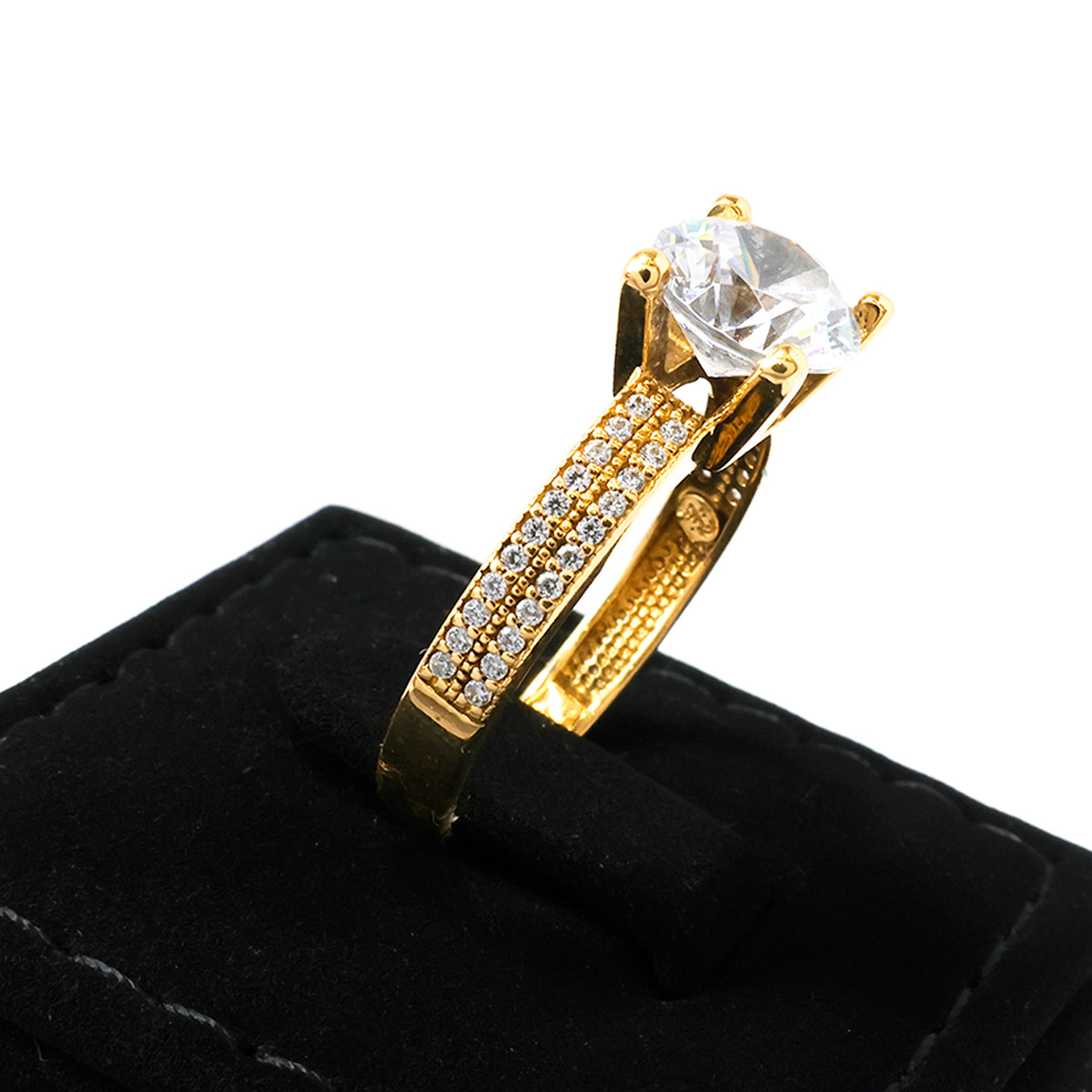 Gold ring with a large diamond and smaller diamonds on a black cushion