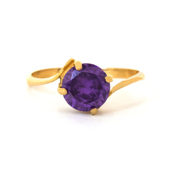Gold ring with a purple gemstone on a white background