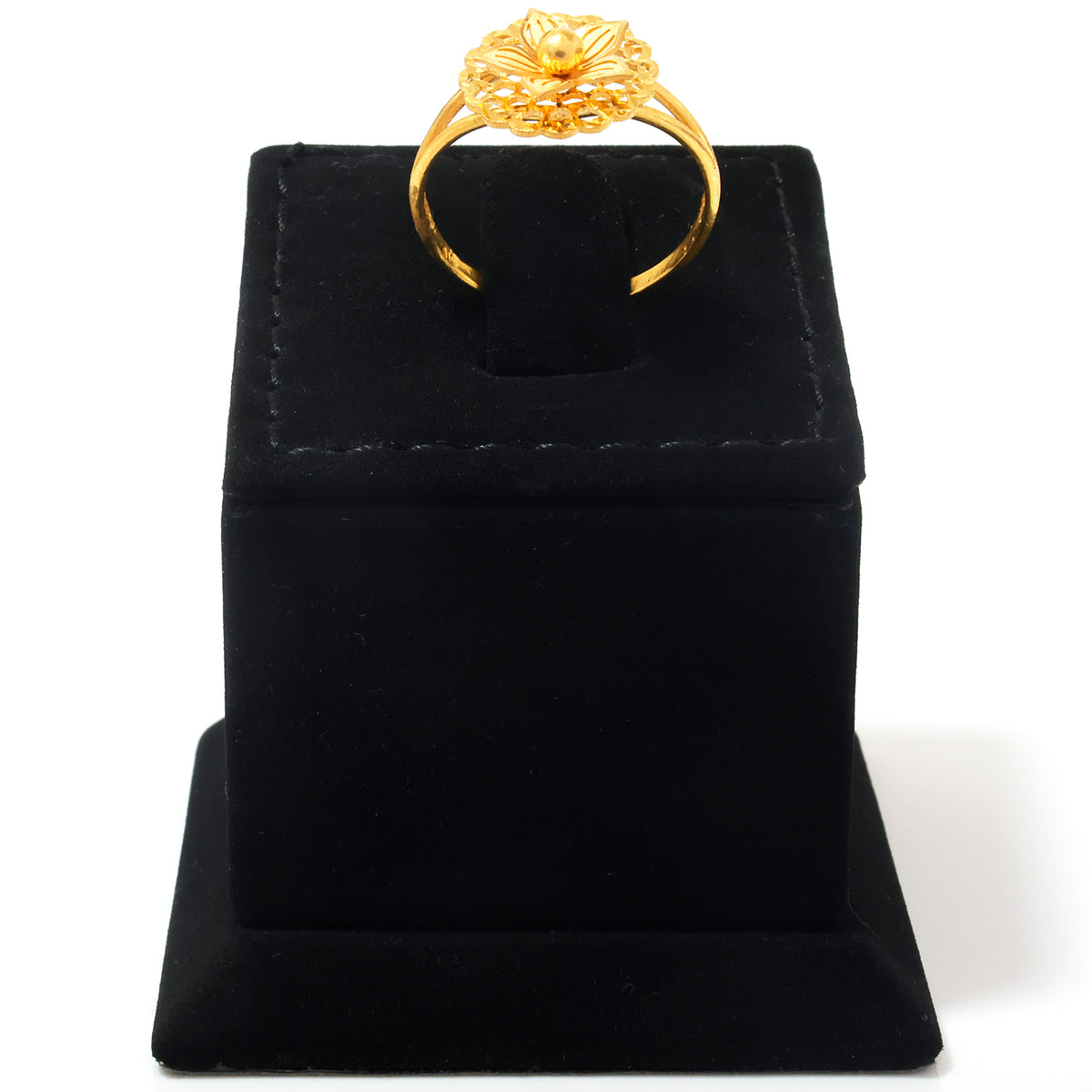 A gold ring with an intricate floral or lotus-shaped crown setting, displayed on a black velvet ring box against a white background.