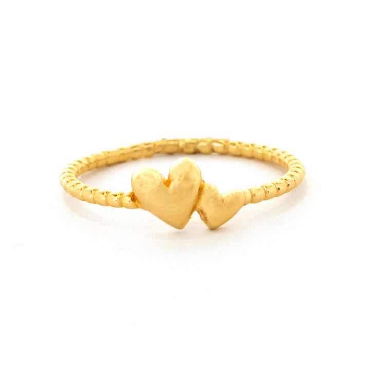 Gold ring with a heart design on a white background
