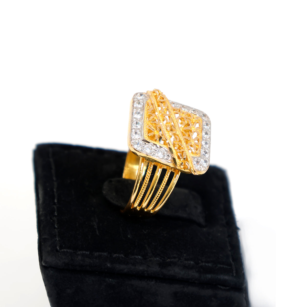 Gold ring with diamond accents on a black velvet stand against a white background