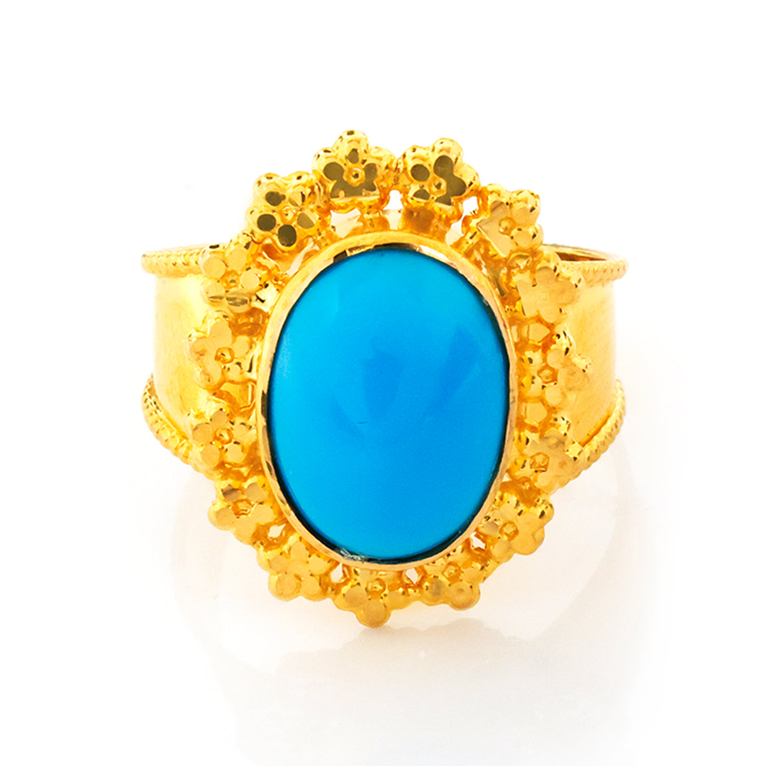 Gold ring with a blue stone on a white background