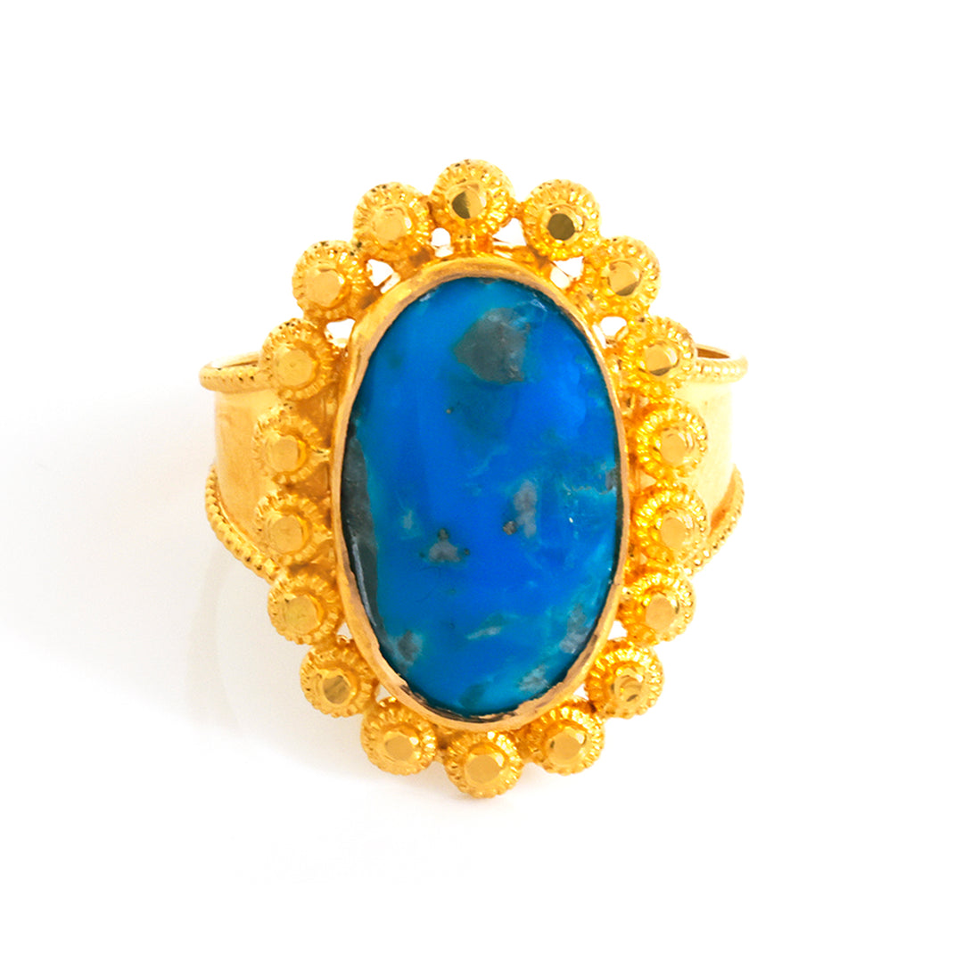 Gold ring with a blue stone on a white background