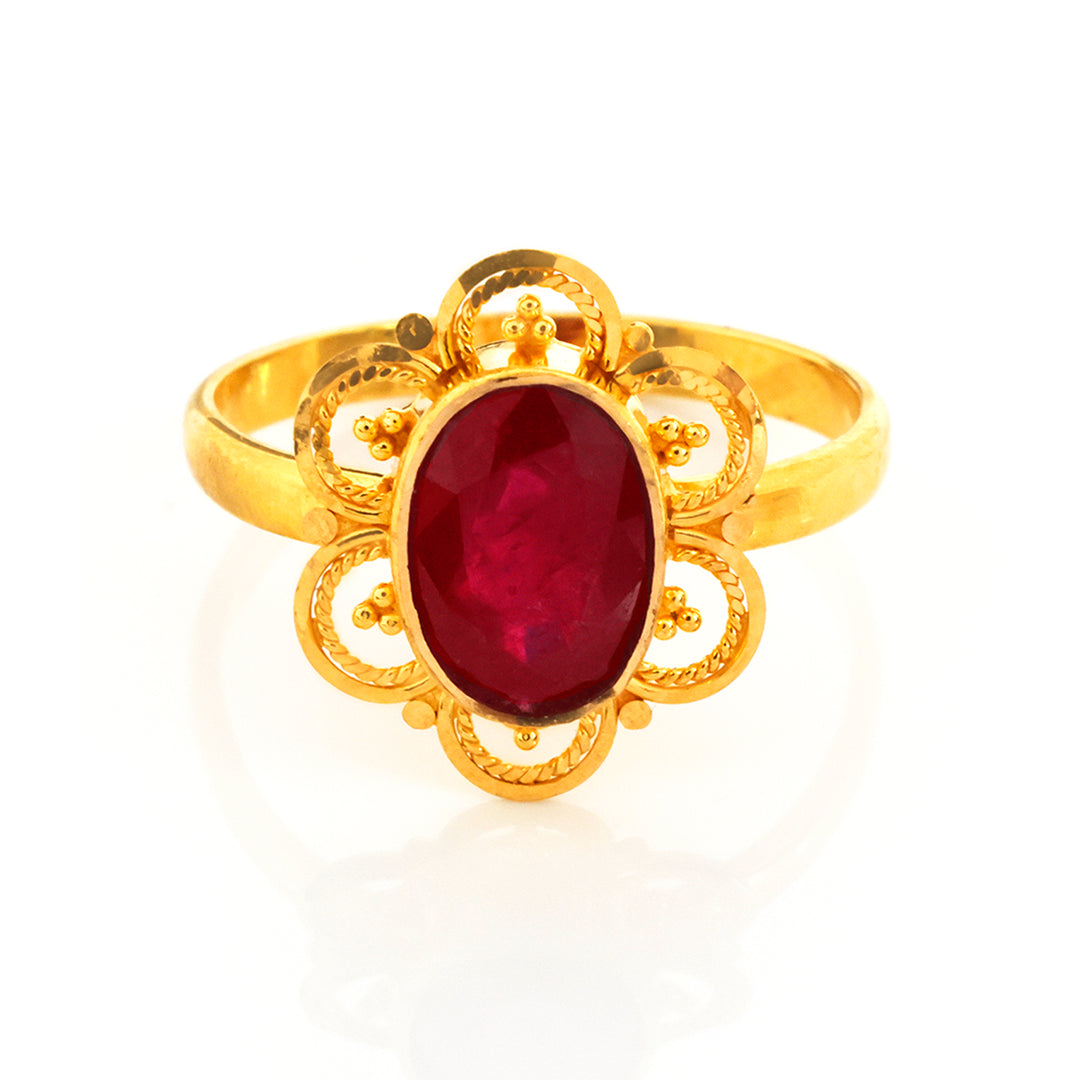 Gold ring with a red gemstone on a white background