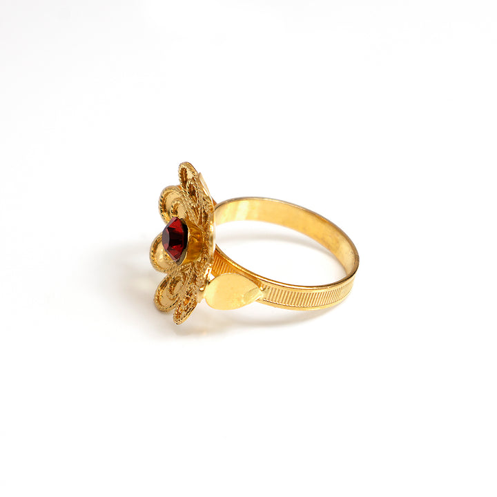 Gold ring with a red gemstone on a white background