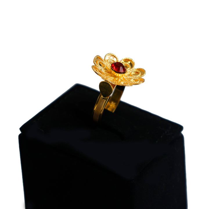 Gold ring with a red gemstone on a black cloth against a white background - zero making charge