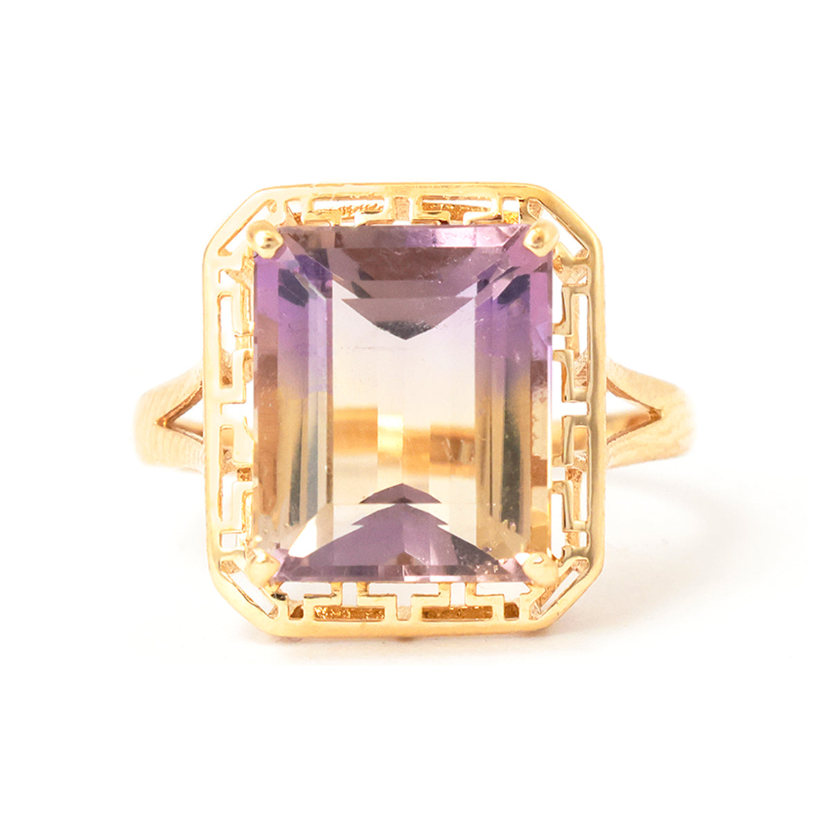 Gold ring with a rectangular purple gemstone on a white background