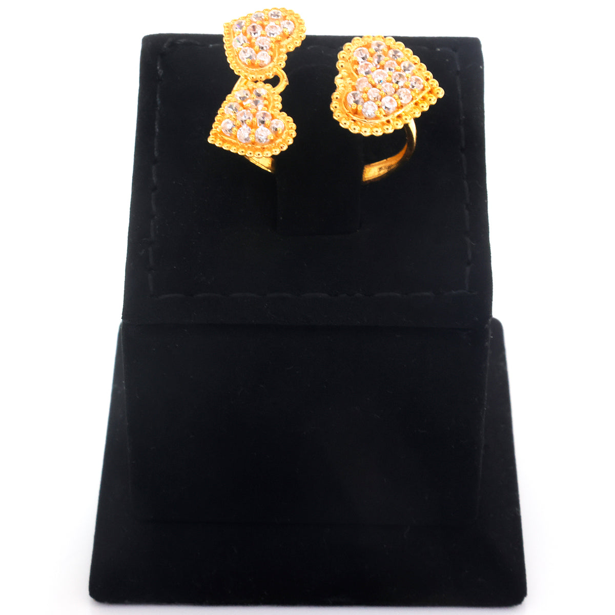 Gold heart-shaped ring and matching drop earrings with clear rhinestones, displayed on a black velvet jewelry stand against a white background.