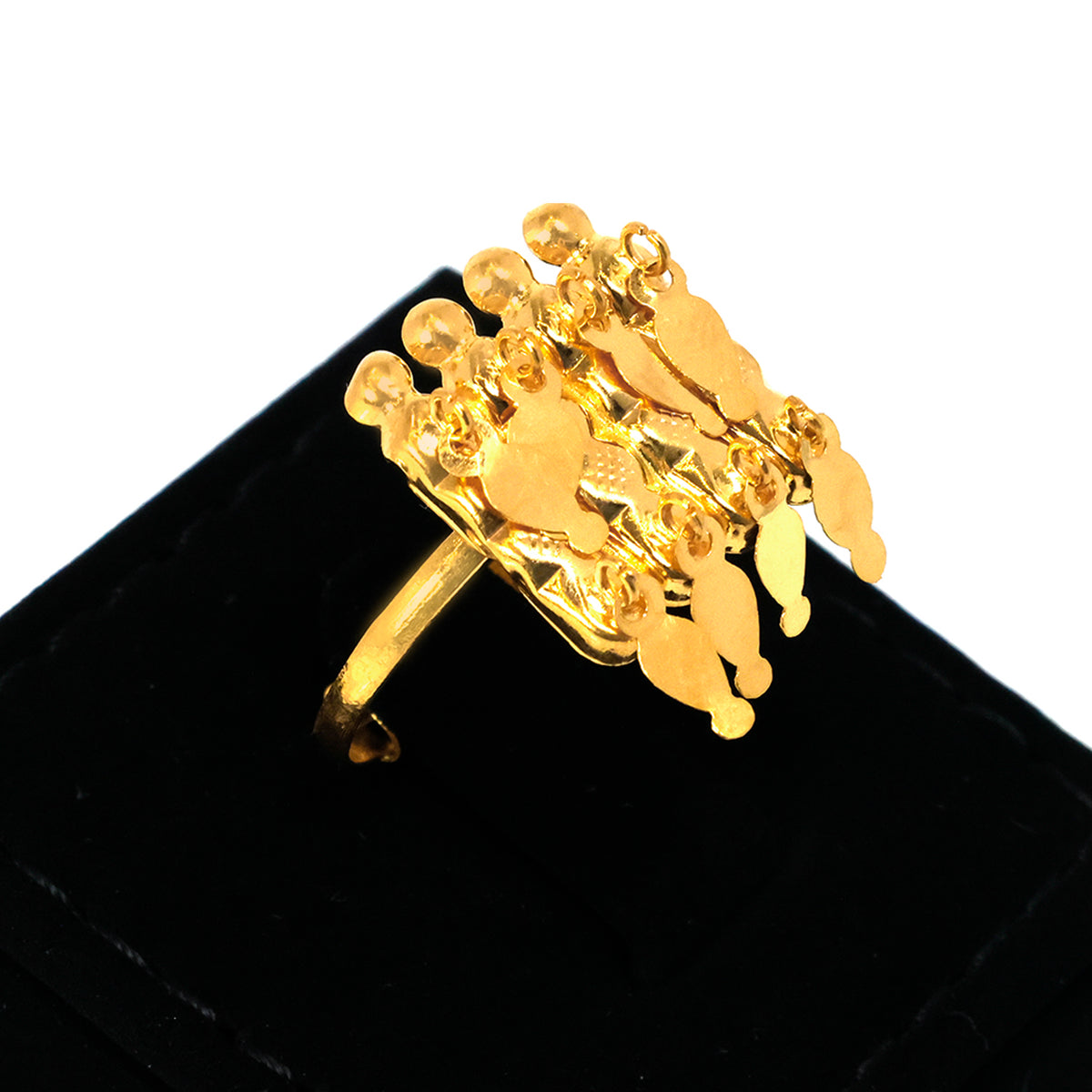 Gold ring with intricate design on a black stand