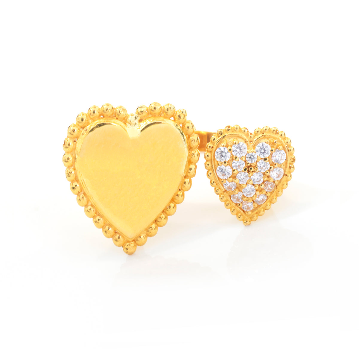 A pair of gold heart-shaped stud earrings on a white background. One earring features a smooth, polished gold heart with a beaded border, while the other features a floral arrangement of clear pavé stones in a gold heart frame.
