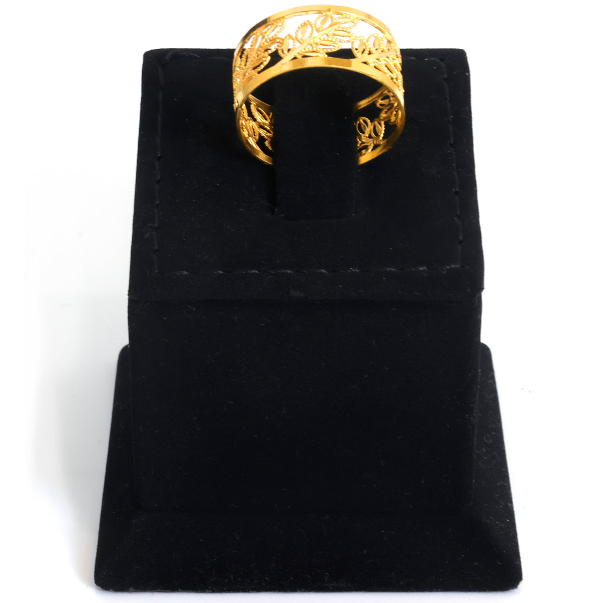 A gold ring with an intricate floral filigree cutout pattern, displayed on a black velvet jewelry stand against a white background.