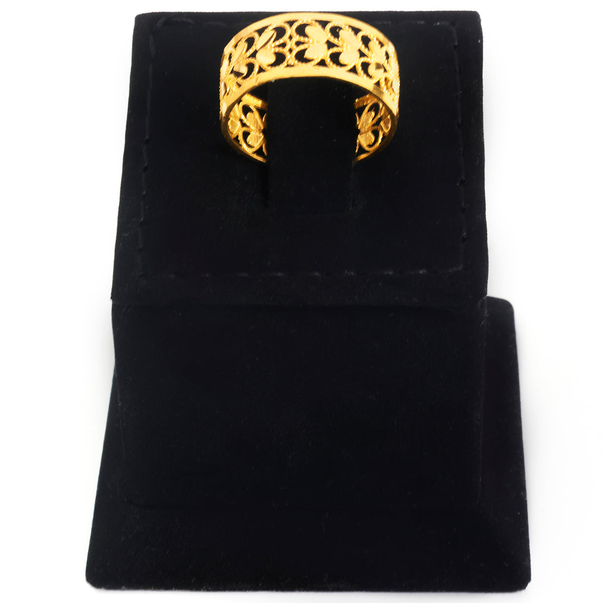A gold ring with an intricate openwork floral filigree pattern, displayed on a black velvet jewelry stand against a white background.